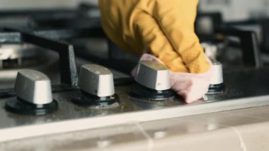 Mutfak fayanslarını sarı eldivenlerdeki kurumdan temizleyin. Evde temizlik.