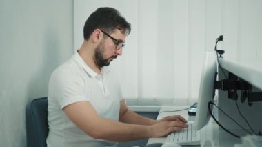 Beyaz dişçi resepsiyonda bilgisayarın başında oturuyor ve hastayı kaydediyor.