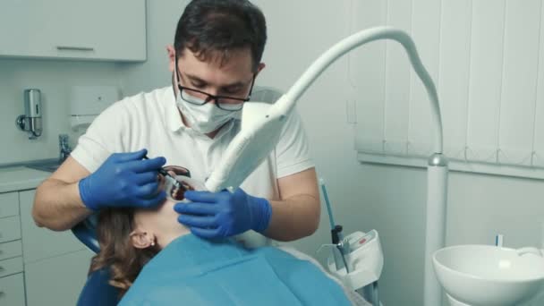 Dentista faz um procedimento para clareamento dos dentes. Belo sorriso. Lâmpada ultravioleta para clareamento dos dentes — Vídeo de Stock