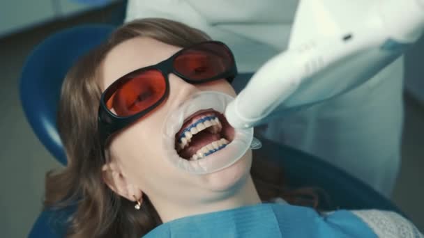 歯医者は歯を白くする手順を行います。いい笑顔だ。歯を白くするための紫外線ランプ — ストック動画