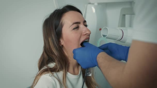 A gloved dentist makes an X-ray of the teeth and shows it to the patient on a digital screen. Dental care — Stock Video