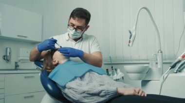 Dişçi diş beyazlatma için bir prosedür yapar. Güzel gülümseme. Diş beyazlatma için morötesi lamba