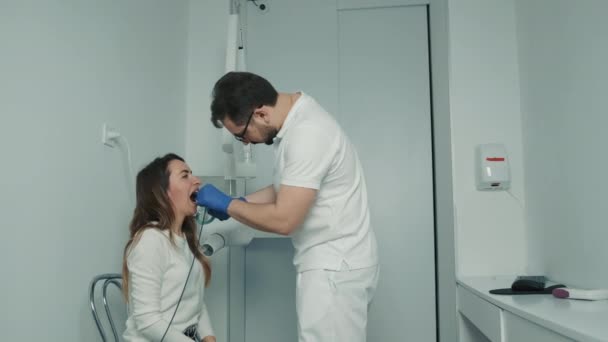 Un dentista con guantes hace una radiografía de los dientes en el consultorio dental. Cuidado dental y una hermosa sonrisa — Vídeos de Stock