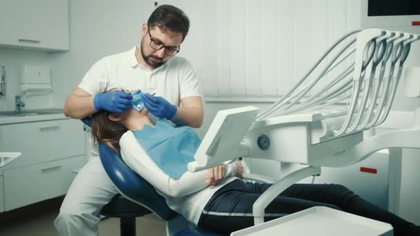 Dentista inyecta una inyección analgésica en el paciente antes de llenar el diente — Vídeos de Stock