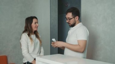 Muayene için dişçide bir hasta. Adam diş bakımı için diş macunu öneriyor.