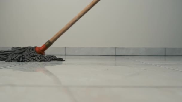 Detailní záběr mop pohybující se po podlaze na dlaždici. Čištění a čistota — Stock video