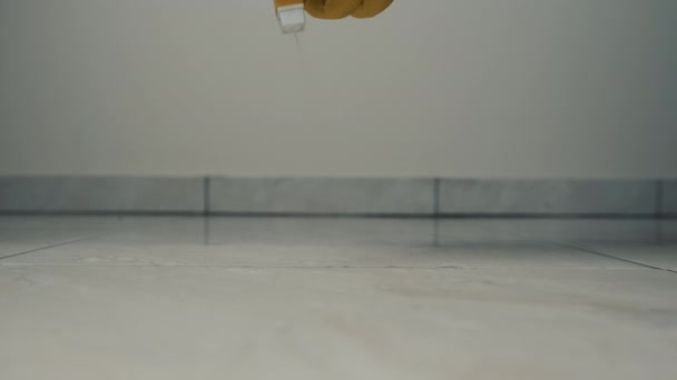 Close-up frame of a hand in yellow gloves wiping a tile with a rag on the floor. Shine and cleanliness with detergents. Cleaning — Stock Video