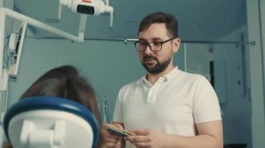 Diş hekimi hastayla protez ve diş renginin yenilenmesi ve rehabilitasyonu hakkında konuşur.