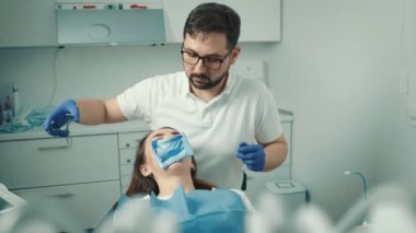 Dişçi diş beyazlatma için bir prosedür yapar. Güzel gülümseme. Diş beyazlatma için morötesi lamba