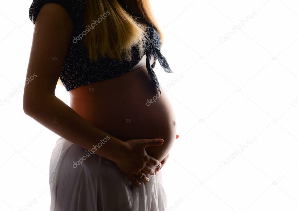 Cropped silhouette of a young pregnant woman isolated on a white background. Beauty and tender motherhood.