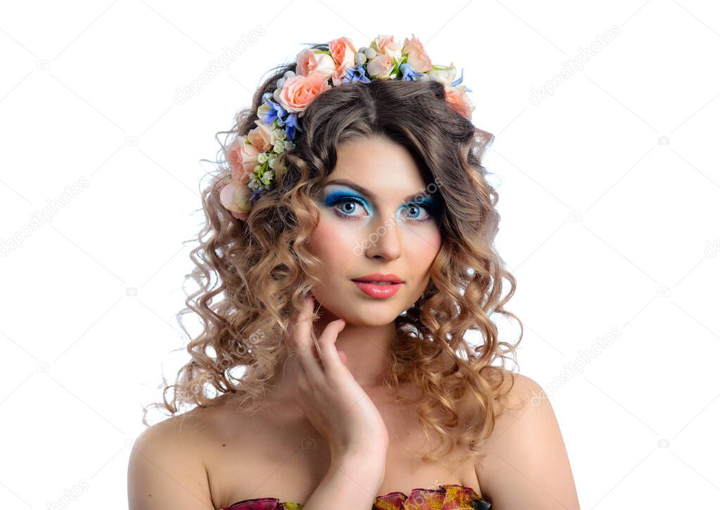 Young beautiful girl with colorful makeup and flower wreath in her curly hair. Blue eye shadow and red lipstick. Isolate on a white background.