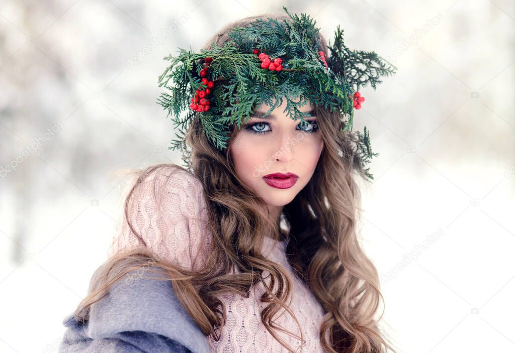 Beautiful fashionable woman with a fir wreath in her hair. Winter beauty portrait outdoor