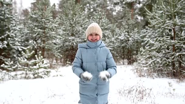 快乐的小女孩在美丽的冬季森林里玩雪 穿着保暖衣服的孩子 冬天散步和积极休息 慢动作 — 图库视频影像