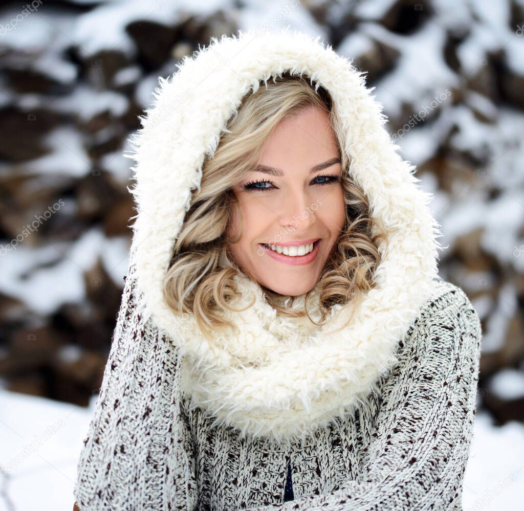 A beautiful winter woman with white teeth and a perfect smile. Happy sincere outdoor portrait of a young attractive model