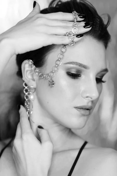 Beautiful woman with a chain in her hands. Beauty portrait with jewelry