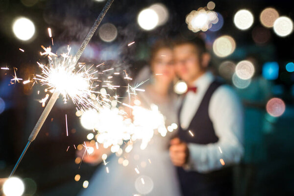 Colorful blurry fireworks in beautiful night. Newlyweds in love