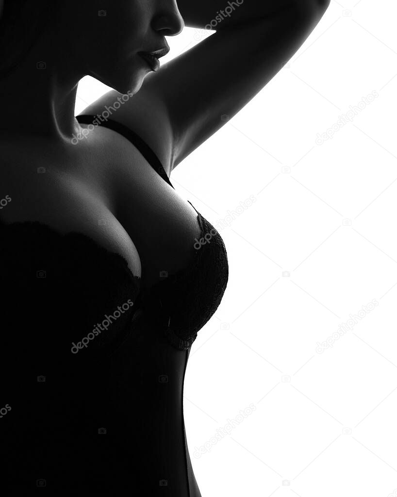 Sensual woman with big breasts in a black bra isolated on a white background. The concept of sexy underwear