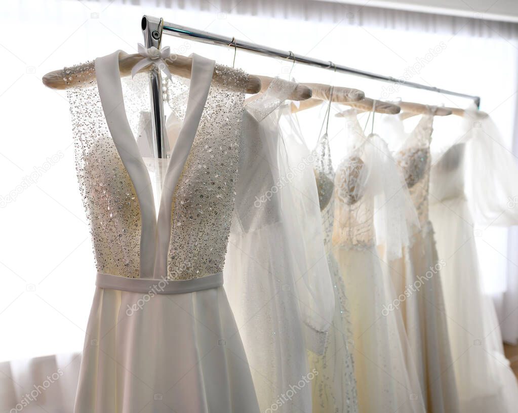 Wedding dresses hang on a hanger in the store or wedding showroom