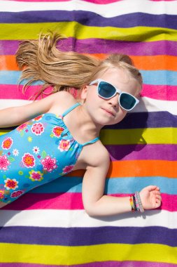 küçük kız bir plaj havlusu yalan