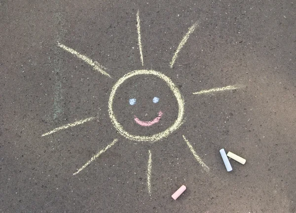 Chalk drawn sun on asphalt