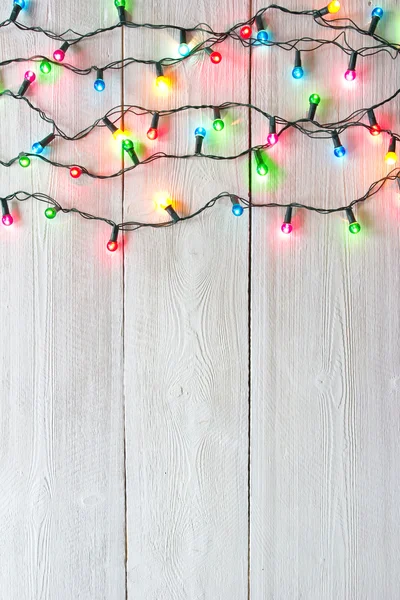 Lumières de Noël sur des planches peintes en blanc pour le fond — Photo