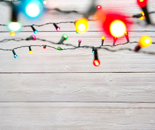 Christmas lights over white painted planks — Stock Photo, Image