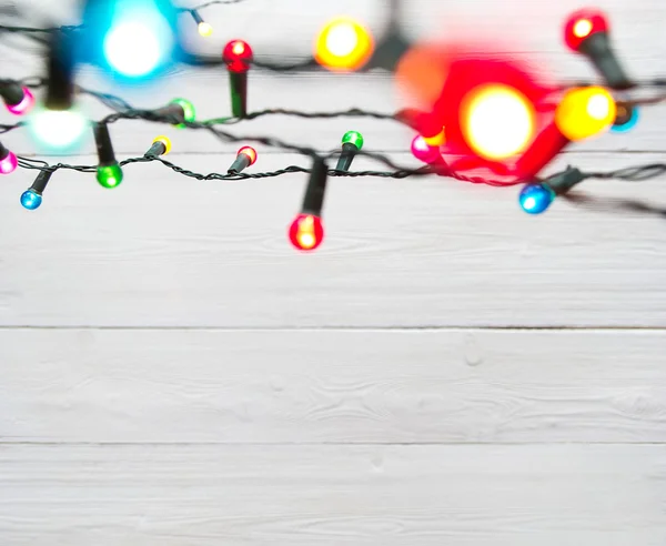 Χριστουγεννιάτικα φώτα πάνω από το λευκό βαμμένο σανίδες — Φωτογραφία Αρχείου