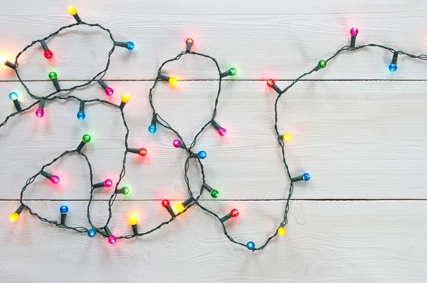 Christmas lights over white painted planks — Stock Photo, Image