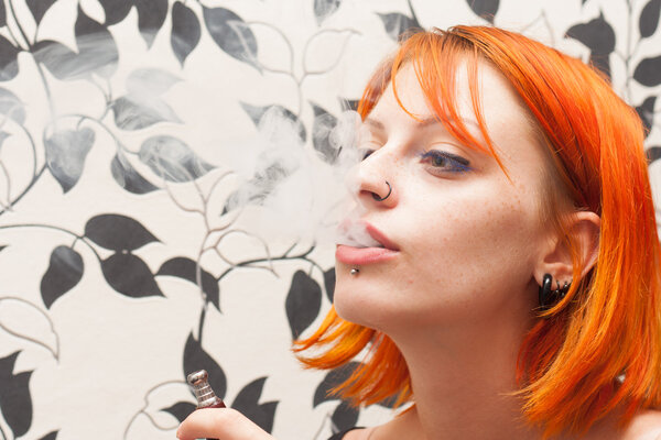 Рыжая девушка курит
