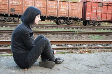 Raylar yakınındaki kız sit