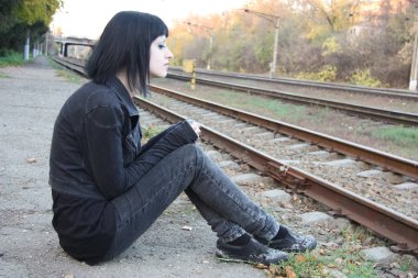 Raylar yakınındaki kız sit