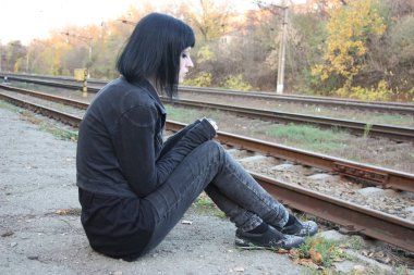 Raylar yakınındaki kız sit