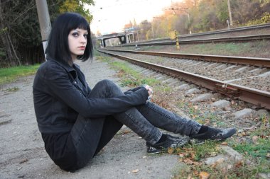 Raylar yakınındaki kız sit