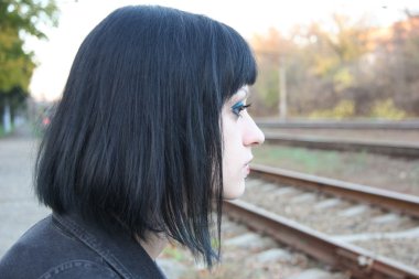 Raylar yakınındaki kız sit