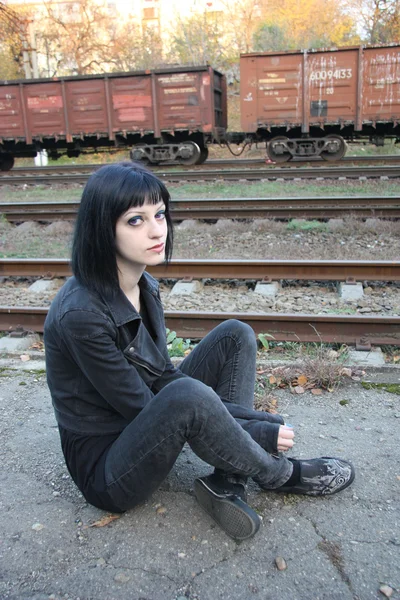 女孩坐在铁轨附近 — 图库照片