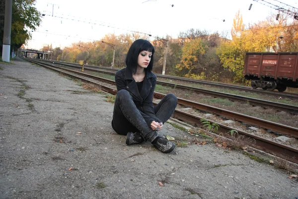 Raylar yakınındaki kız sit