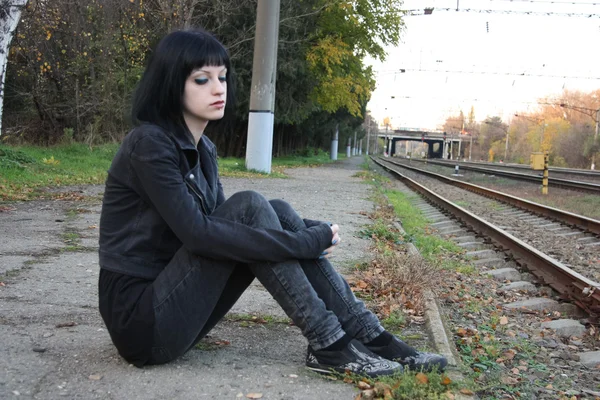 Raylar yakınındaki kız sit