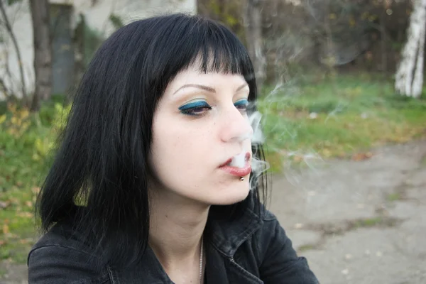 Chica sentarse y fumar cerca de rieles — Foto de Stock