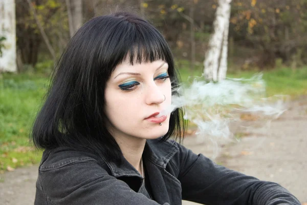 Chica sentarse y fumar cerca de rieles — Foto de Stock