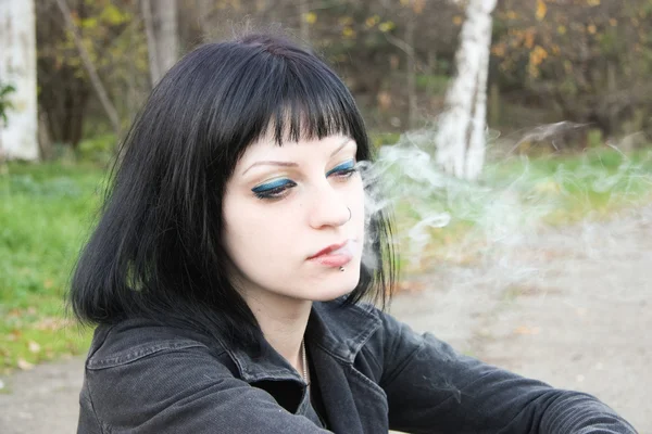 Chica sentarse y fumar cerca de rieles —  Fotos de Stock