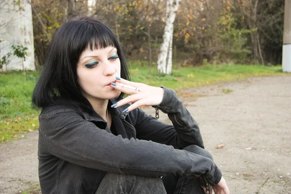 Dívka sit a kouř poblíž kolejnice — Stock fotografie