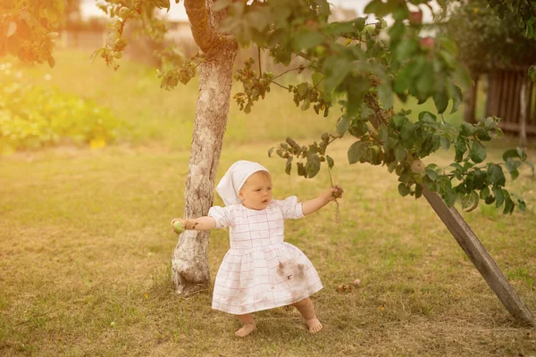 Küçük bir kız bir elma ağacının altında dikilirken istikrarsız yürümeyi öğrenir. Köyde çıplak ayaklı pis bir çocuk.