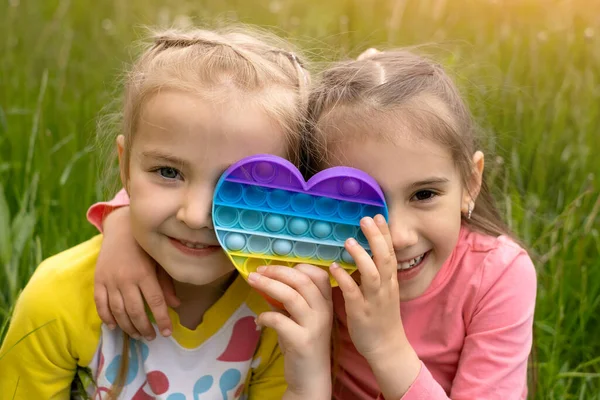 Zwei Kleine Mädchen Spielen Mit Einem Modernen Herzförmigen Pop Spielzeug — Stockfoto