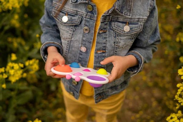 Ein Kind Hält Ein Beliebtes Einfaches Grübchenspielzeug Einem Rapsfeld Nützliches — Stockfoto