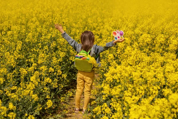 Ein Mädchen Einem Rapsfeld Mit Einem Rucksack Voller Moderner Pädagogischer — Stockfoto