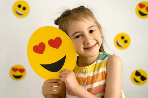 Una Chica Sonriendo Con Todos Sus Dientes Sostiene Emoji Amor —  Fotos de Stock