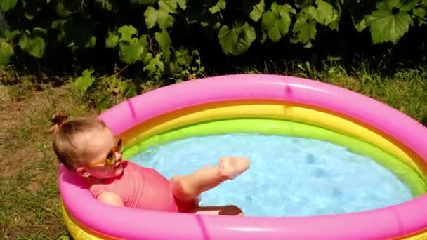 Uma Criança Espirra Uma Pequena Piscina Infantil Inflável Com Água — Vídeo de Stock