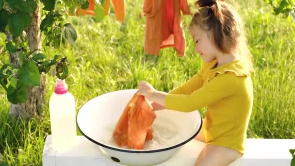 Ein Mädchen Wäscht Kleidung Mit Flüssigem Waschpulver Aus Einer Flasche — Stockvideo