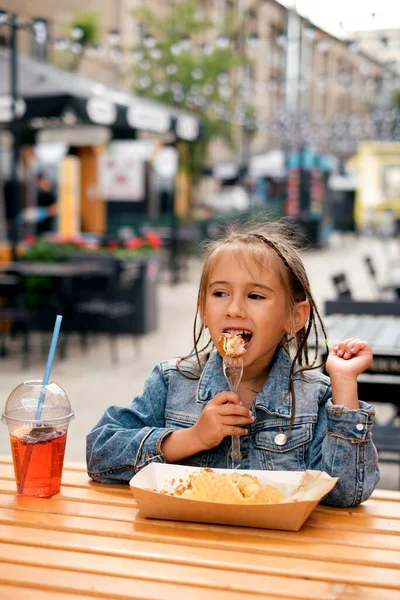 Seorang Gadis Kecil Bergaya Dalam Jaket Denim Makan Makanan Cepat — Stok Foto