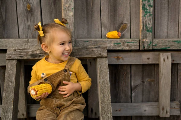 소녀는 옥수수를 계단에 즐겁게 평상복을 입은아이 시골에서 — 스톡 사진